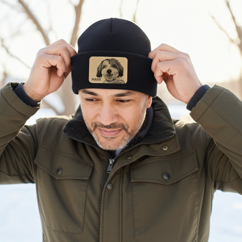 Man wearing a black beanie with a dog's face patch outdoors