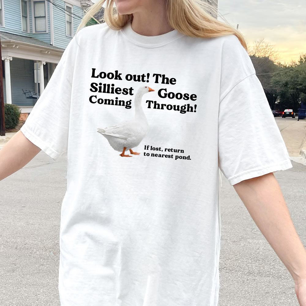 Person wearing a white t-shirt with a humorous goose graphic and text.