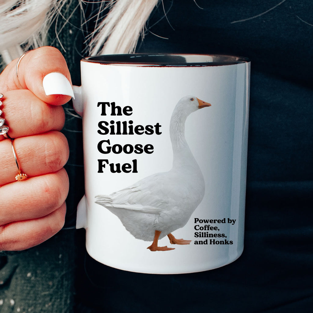 Mug with a goose design and text held by a person