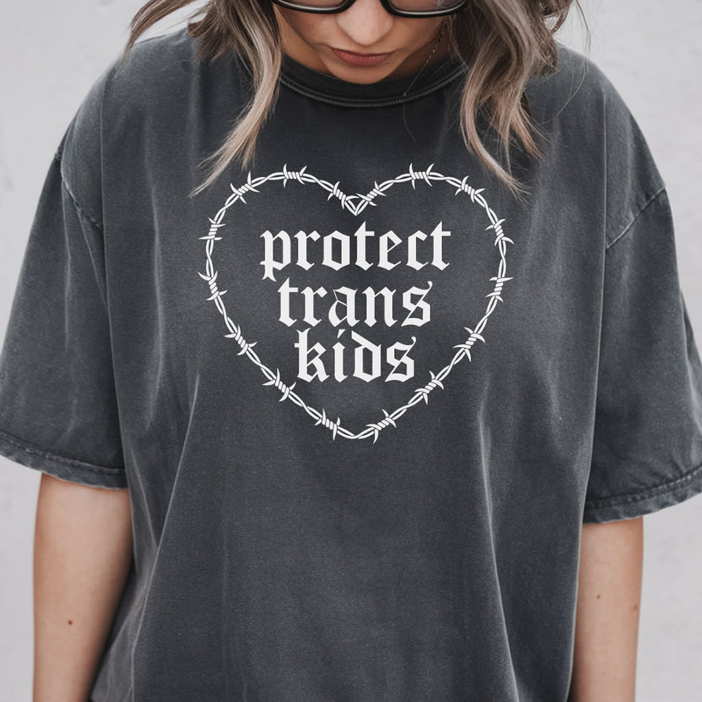 Person wearing a pepper t-shirt with 'protect trans kids' design on a plain background