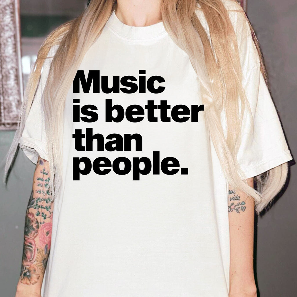 Person wearing a white t-shirt with 'Music is better than people.' text.